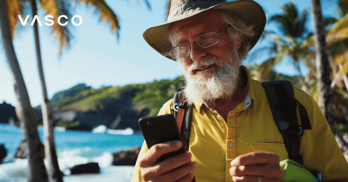 Stariji muškarac provjerava svoj telefon na egzotičnoj plaži.