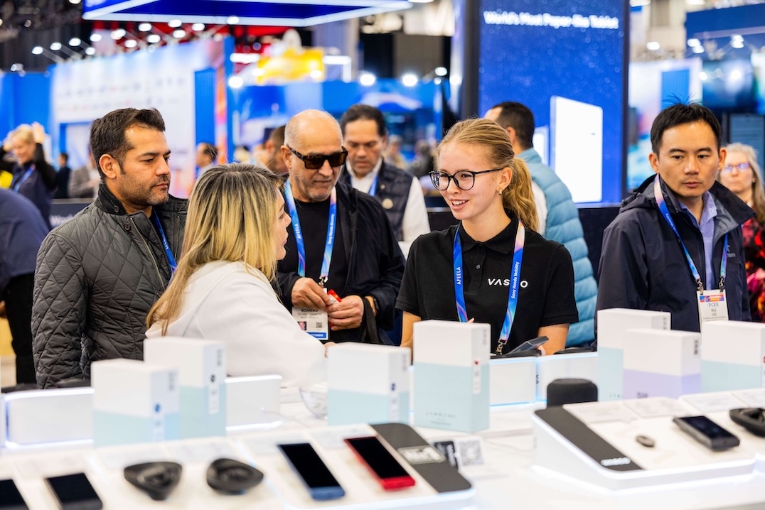 CES 2026 Smiješna skupina ljudi razgovara na štandu Vasco Electronics na CES-u 2026.