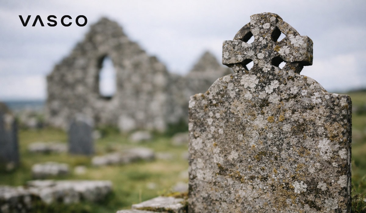 istrošeni keltski križ u blizini drevnih kamenih ruševina