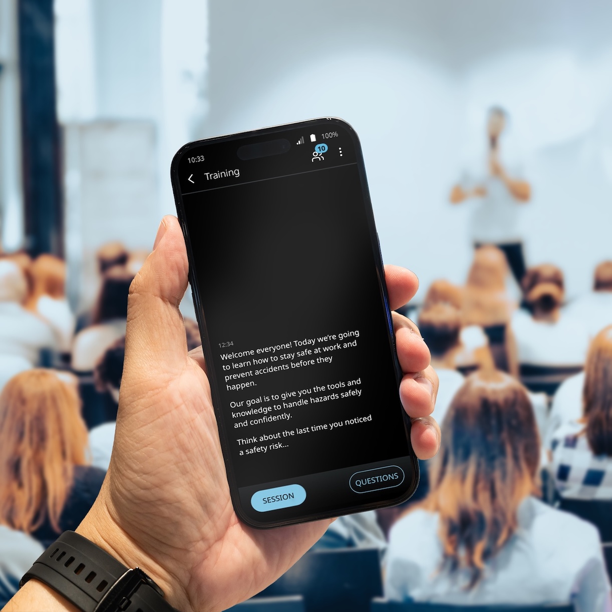 Vasco Audience Predavanje se održava u prostoriji punoj ljudi. Muškarac drži telefon u ruci i prikazuje prijevod putem Vasco Audience