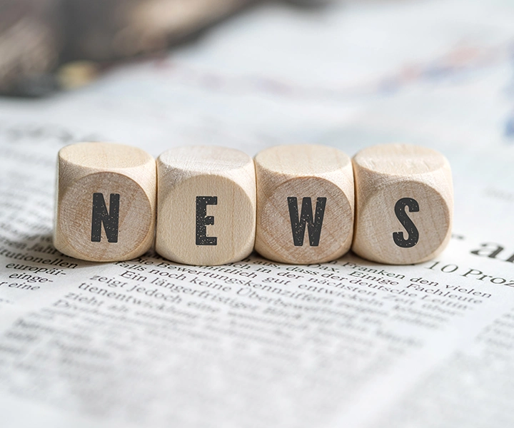 Blokovi s riječju 'NEWS' leže na novinama.